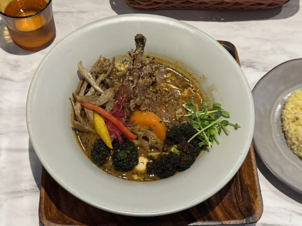 Curry en sopa de TREASURE con arroz en un plato aparte